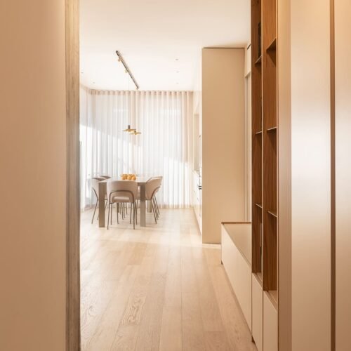 Soggiorno open space con arredi su misura e palette cromatica calda a Rimini